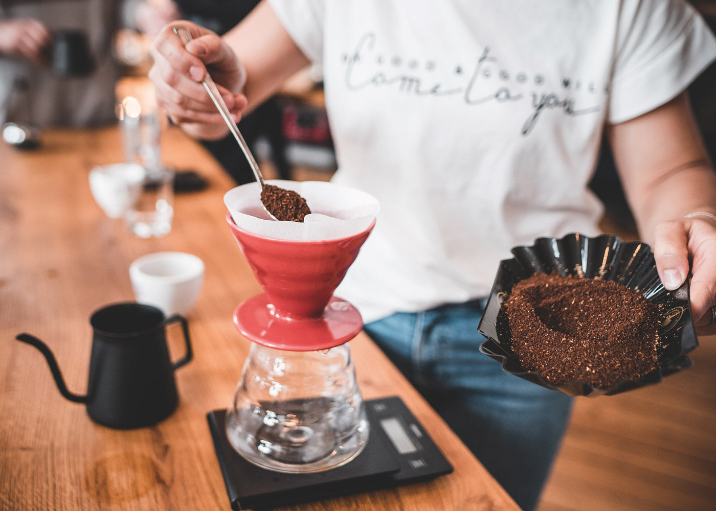 Person ist bei der Kaffeezubereitung mit Handfilter