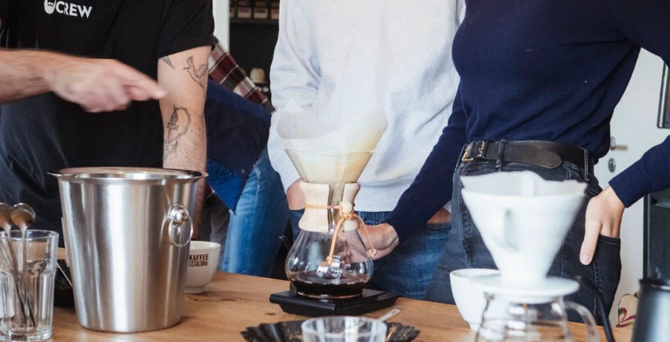 Personen stehen vor Kaffee bei Kaffeeseminar